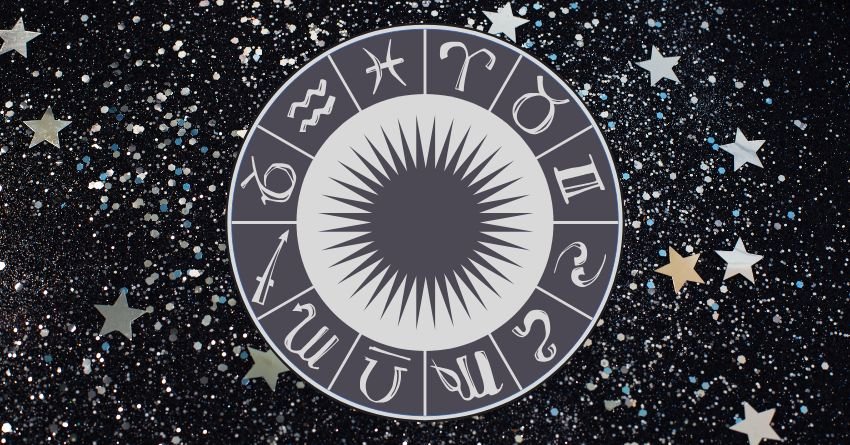 Silver zodiac wheel surrounded by dark celestial patterns and glowing white details