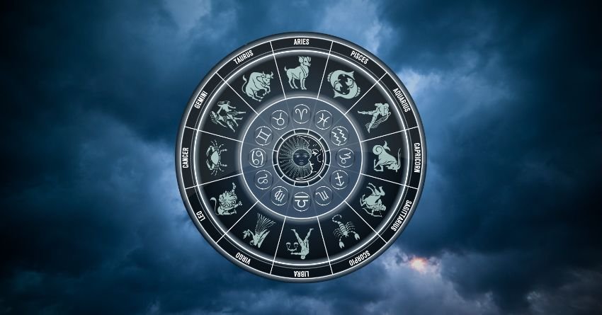 Mystical zodiac circle with astrological symbols against a dark blue cloudy sky